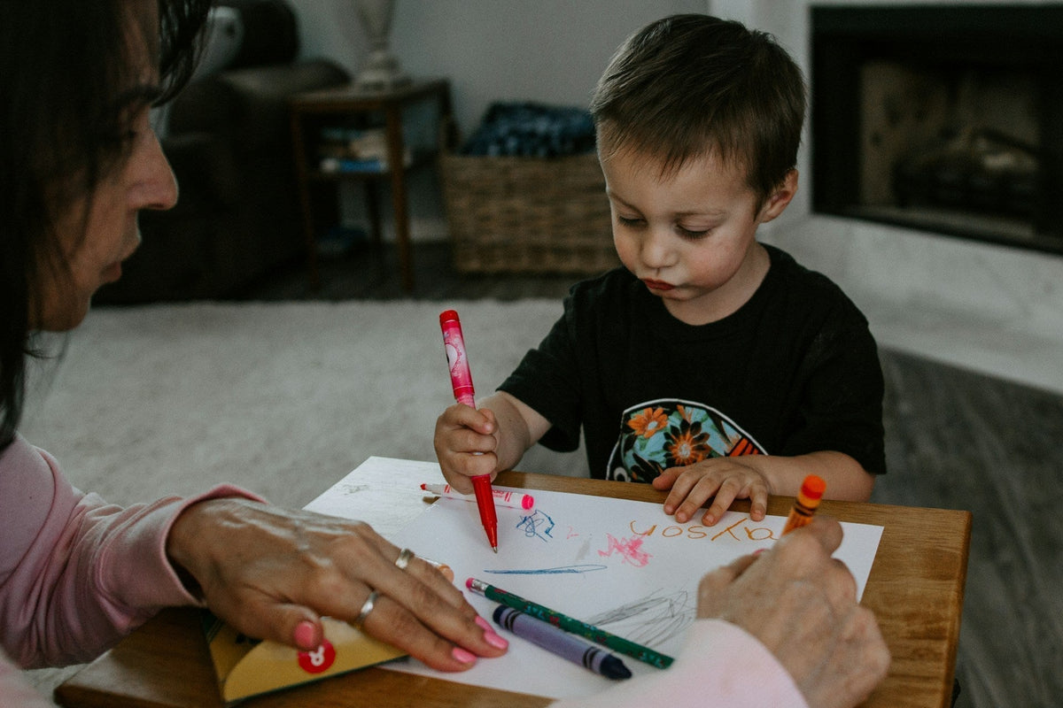 Boy practicing handwriting with markers