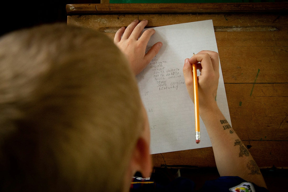 child practicing handwriting on lined paper