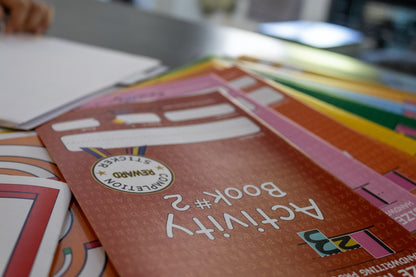 Close-up of a colorful handwriting activity book displayed with additional workbook materials used for handwriting instruction.